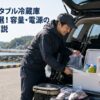 港で車の荷室にある白い保冷ボックスへ魚や飲み物を収納する釣り人の男女