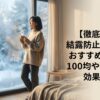 結露した冬の窓辺で温かい飲み物を持つ女性